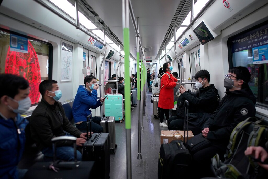 Passengers wearing face masks ride a subway train on the first day the city's subway services resumed following the novel coronavirus disease (COVID-19) outbreak, in Wuhan of Hubei province, the epicentre of China's coronavirus outbreak, March 28, 2020. REUTERS/Aly Song - RC2SSF9A3QMB