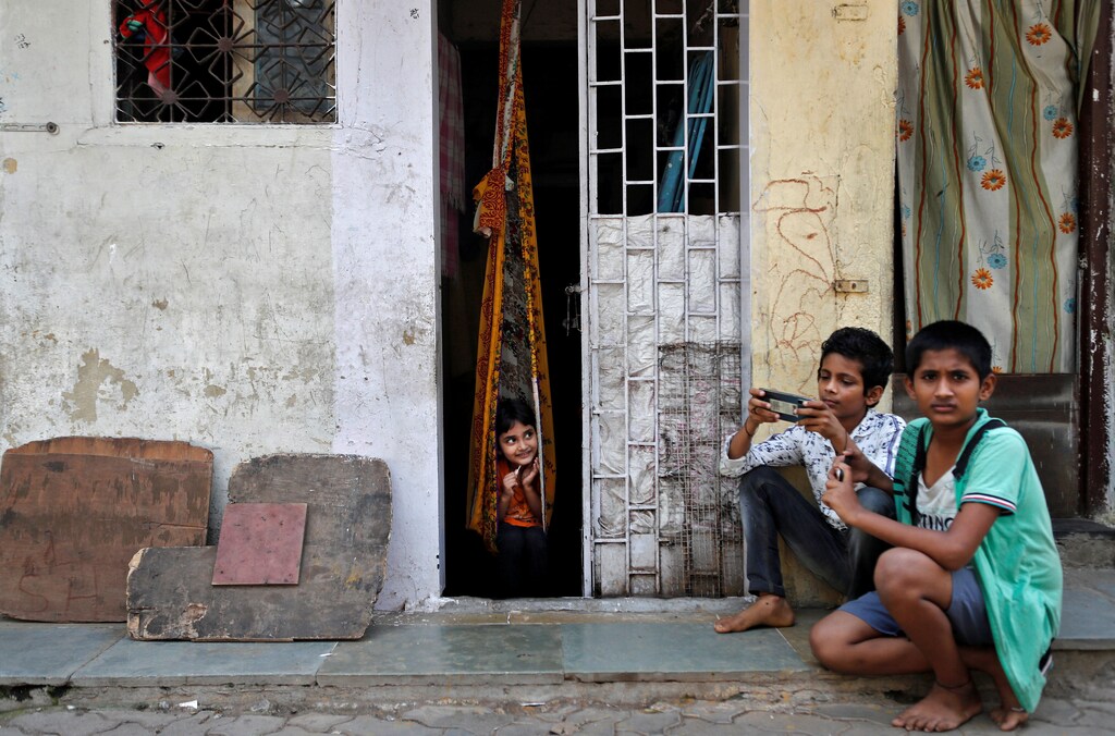 Children play outside a house, during a nationwide lockdown in India to slow the spread of COVID-19, in Dharavi, one of Asia's largest slums, during the coronavirus disease outbreak, in Mumbai, India, April 10, 2020. REUTERS/Francis Mascarenhas SEARCH "CORONAVIRUS MUMBAI SLUM" FOR THIS STORY. SEARCH "WIDER IMAGE" FOR ALL STORIES. - RC2Z7G9BIT8M