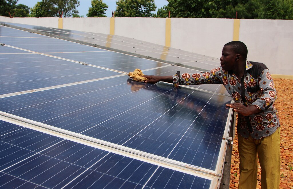A technician cleans solar panels, part of the BBOXX and EDF solar energy system used to provide electricity to Sikpe Afidegnon village, Togo May 16, 2019. Picture taken May 16, 2019. REUTERS/Noel Kokou Tadegnon