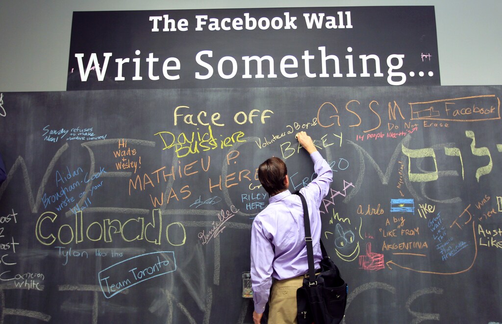 An employee writes a note on the message board at the new headquarters of Facebook in Menlo Park, California January 11, 2012. The 57-acre campus, which formerly housed Sun Microsystems, features open work spaces for nearly 2,000 employees on the one million square foot campus, with room for expansion. Picture taken January 11, 2012. REUTERS/Robert Galbraith (UNITED STATES - Tags: SCIENCE TECHNOLOGY MEDIA TPX IMAGES OF THE DAY) - GM1E81D0BPF01