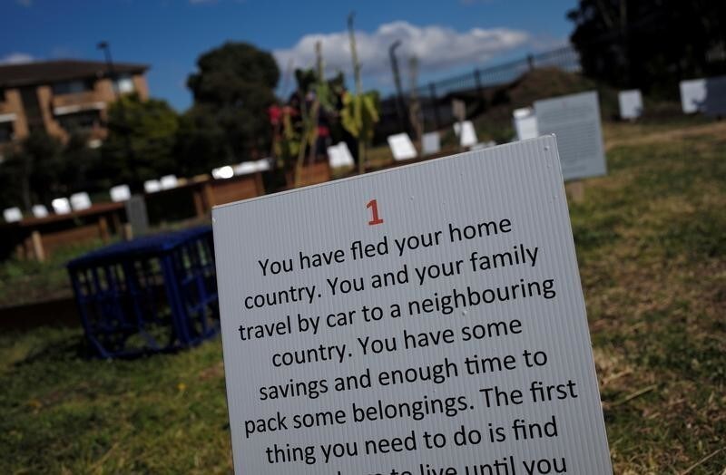 A sign asking people to make decisions that would affect their lives in the same manner as real refugees is displayed at the "Refugee Camp in my Neighbourhood" installation at a Sydney park in Australia, August 7, 2017. The temporary "refugee camp" project, established by a local Sydney council, has been set up to replicate the real life conditions of refugee camps around the world and employs former refugees as tour guides to educate Australians on the plight of millions displaced by humanitarian emergencies globally. REUTERS/Jason Reed - RC115CA6E1A0