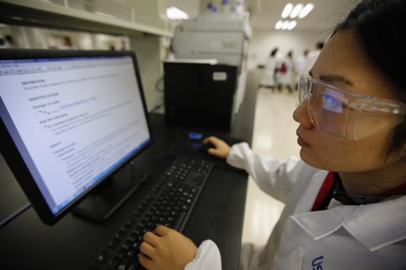An employee of the U.S. Pharmacopeial Convention company, part of the Shanghai Free Trade Zone, works at the company's lab during a government organized media tour in Shanghai, September 24, 2014. A disappointing first year for Shanghai's much-hyped free-trade zone, seen as a pet project of Premier Li Keqiang and billed as a reform laboratory, raises questions about China's commitment to opening up its markets as it wrestles with a slowing economy. The 29 square kilometre zone on the outskirts of China's commercial capital - hailed as Beijing's boldest reform in decades - was meant to test changes such as currency liberalisation, market-determined interest rates and free trade.But progress has been slow and policies vague as the political focus has turned from reform to shoring up growth, leaving foreign companies unsure of investing in the free-trade zone (FTZ).
