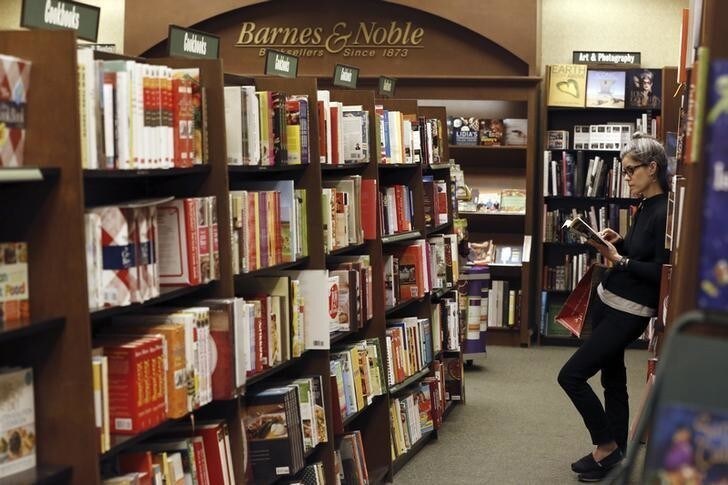 A woman reads a book at a Barnes & Noble bookstore in Pasadena, California November 26, 2013. Barnes & Noble Inc, the largest U.S. bookstore chain, on Tuesday reported a higher than expected quarterly profit as it cut store workers' hours scaled back its money losing Nook business, helping it offset sharp sales declines. REUTERS/Mario Anzuoni (UNITED STATES - Tags: BUSINESS)