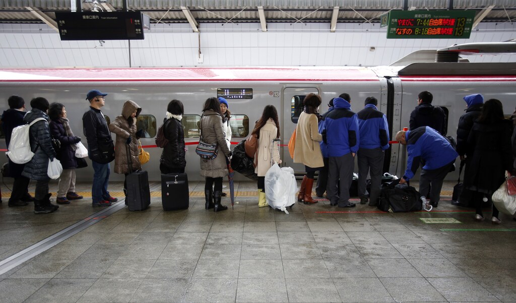 People line up in front of a bullet train at a platform in Tokyo Station as the bullet train service is suspended due to heavy snowfall in Tokyo February 15, 2014. REUTERS/Yuya Shino (JAPAN - Tags: ENVIRONMENT TRANSPORT) - GM1EA2F0TLM01
