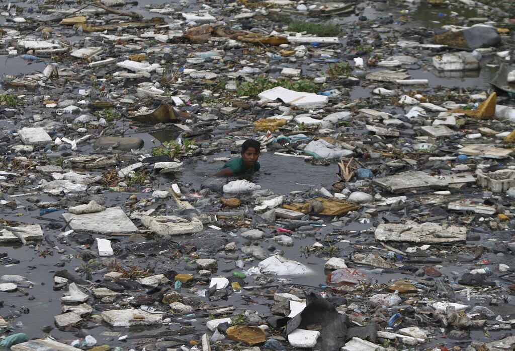 A boy searches for fish in the polluted sea backwaters near marina beach in the southern Indian city of Chennai July 3, 2013. REUTERS/Babu (INDIA - Tags: SOCIETY ENVIRONMENT) - GM1E9731O7D01