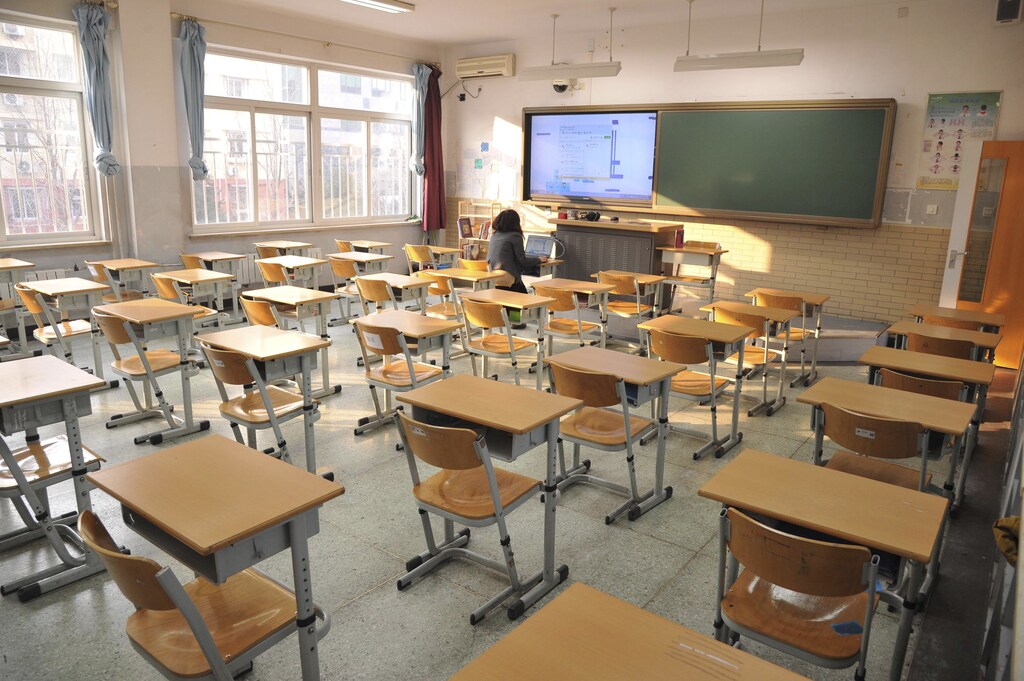 A Chinese language teacher sits in an empty classroom as she teaches a class during an online course at Jingshan School, on a smoggy day under a "red alert" for air pollution, in Beijing, China, December 21, 2015. Schools are recommended to close and outdoor construction is banned under the "red alert" for smog. REUTERS/China Daily ATTENTION EDITORS - THIS PICTURE WAS PROVIDED BY A THIRD PARTY. THIS PICTURE IS DISTRIBUTED EXACTLY AS RECEIVED BY REUTERS, AS A SERVICE TO CLIENTS. CHINA OUT. NO COMMERCIAL OR EDITORIAL SALES IN CHINA. - GF10000272717