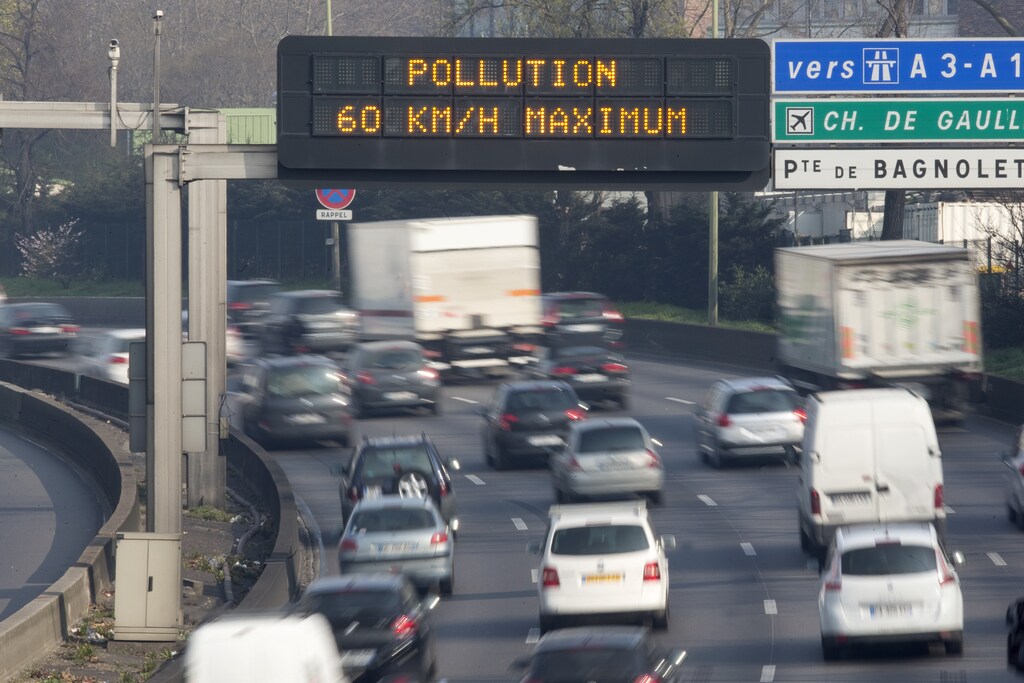 An electronic road sign reads "Pollution, speed limit 60kms" on the Paris ring road.