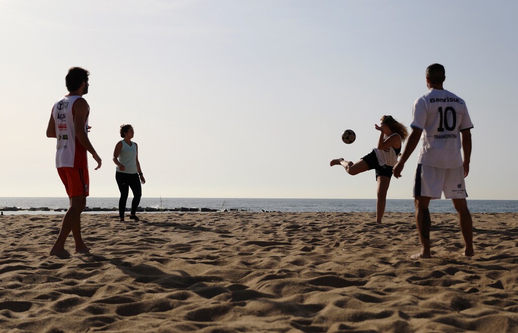 La gente juega mientras disfruta del tiempo soleado en la playa de la Barceloneta en medio de la relajación de las restricciones implementadas para frenar la propagación de la enfermedad coronavirus (COVID-19), en Barcelona, España, el 8 de mayo de 2020.