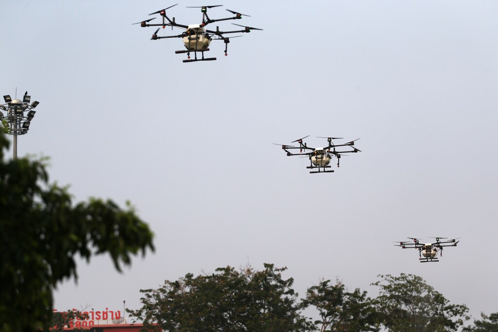Drones fly and spray water during an operation to reduce air pollution near the Giant Swing and Wat Suthat in Bangkok, Thailand, January 31, 2019. REUTERS/Athit Perawongmetha - RC1221E23520