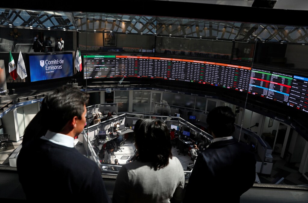 People look at screens displaying foreign exchange rates inside Mexico's Stock Exchange building in Mexico City, Mexico November 23, 2017.