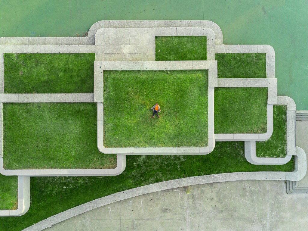 An aerial view of a man lying down on a building rooftop