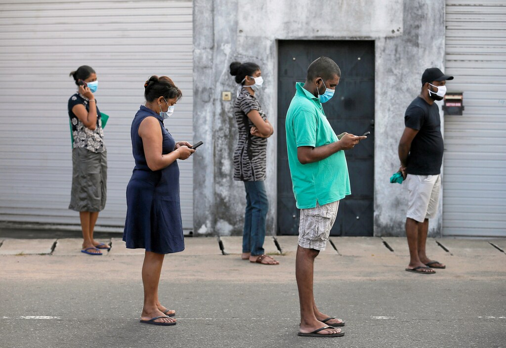 People maintain the one-meter distance in-between each other as they stand in a line to buy groceries at a supermarket during the time government lifted the curfew, as the number of people tested positive for coronavirus disease (COVID-19) in the country increases, in Colombo, Sri Lanka March 24, 2020. REUTERS/Dinuka Liyanawatte TPX IMAGES OF THE DAY - RC27QF910AWZ