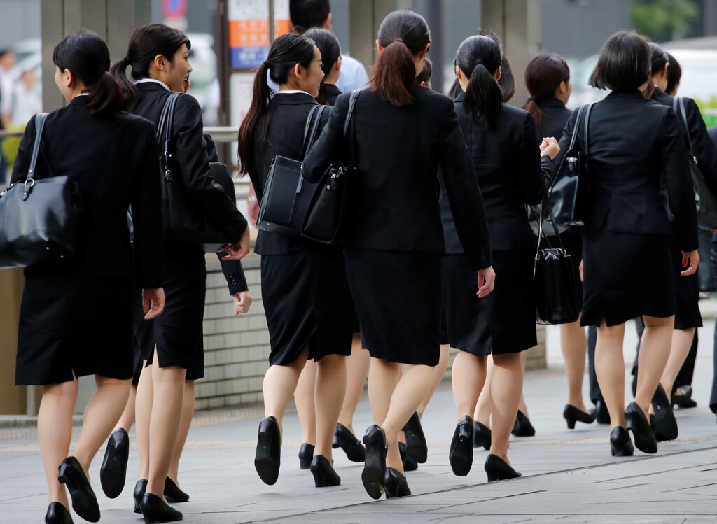 Female office workers wearing high heels, clothes and bags of the same colour make their way at a business district in Tokyo, Japan, June 4, 2019. REUTERS/Kim Kyung-Hoon - RC1A0C81EDF0