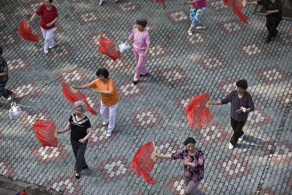 Residents perform a traditional dance as part of a morning exercise in a park in Qingdao, Shandong province July 6, 2008. Qingdao, famous for its local beer and beaches will host the Sailing competitions of the Beijing 2008 Olympic Games as its still facing a huge algae bloom at the city's offshore waters just over a month before the beginning of the games. REUTERS/Nir Elias (CHINA) (BEIJING OLYMPICS 2008 PREVIEW) - RTX7OWK