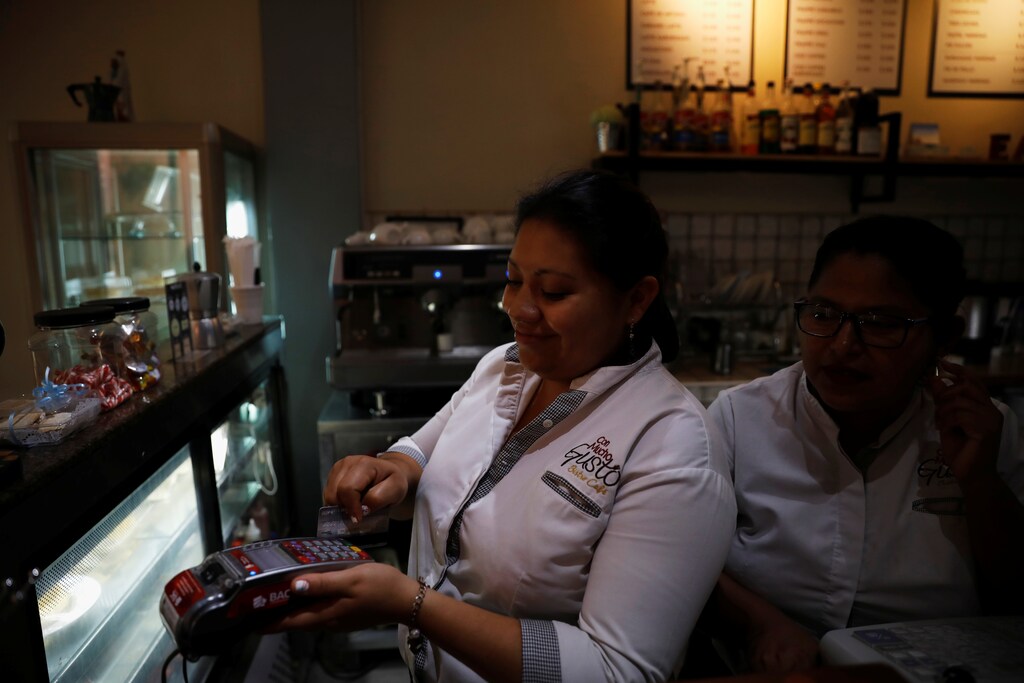 A cashier processes a customer's credit card during payment at a cafe in San Salvador, El Salvador April 4, 2019. REUTERS/Jose Cabezas - RC198CF7D840