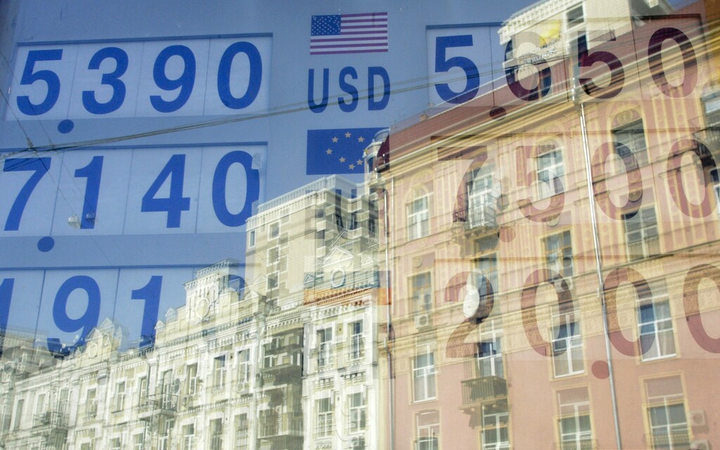 Currency exchange rates are reflected in a window in Kiev October 22, 2008. Prime Minister Yulia Tymoshenko said on Wednesday she hoped Ukraine would receive "substantial" international financial aid next week and set out measures aimed at shielding the country from what she called "stagnation". REUTERS/Konstantin Chernichkin (UKRAINE) - GM1E4AM1OM501