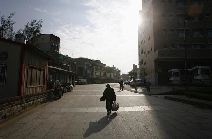 A woman walks along a street at a market in Kinmen County November 25, 2008. Kinmen, which literally means "Golden Door" or "Golden Gate", is a small archipelago of several islands administered by Taiwan which is near Xiamen, China - no more than 2 km (1.2 miles). The island was the site of extensive shelling between Communists and Nationalists forces during the first and second Taiwan straits crisis. REUTERS/Nicky Loh (TAIWAN)