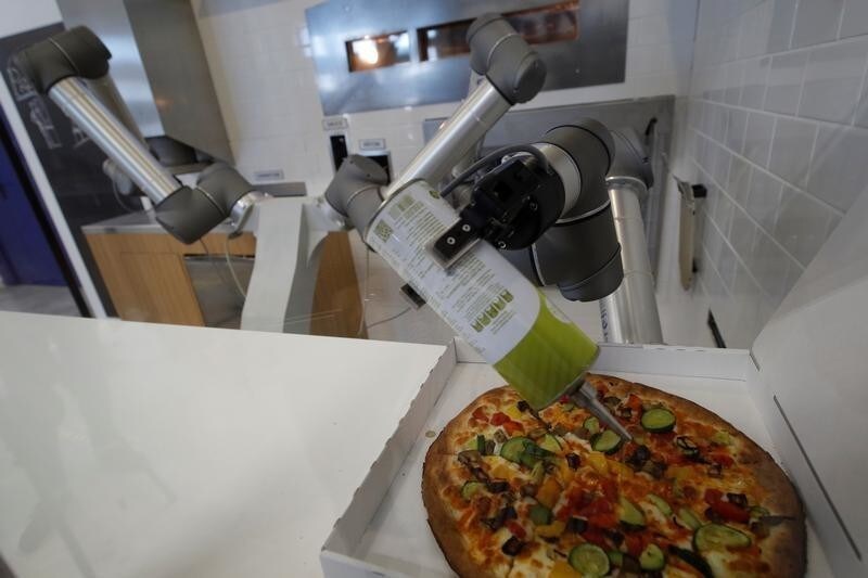 A pizzaiolo robot prepares a pizza before the customers eyes at the showroom of French food startup EKIM in Montevrain near Paris, France, June 26, 2018. Picture taken June 26, 2018.