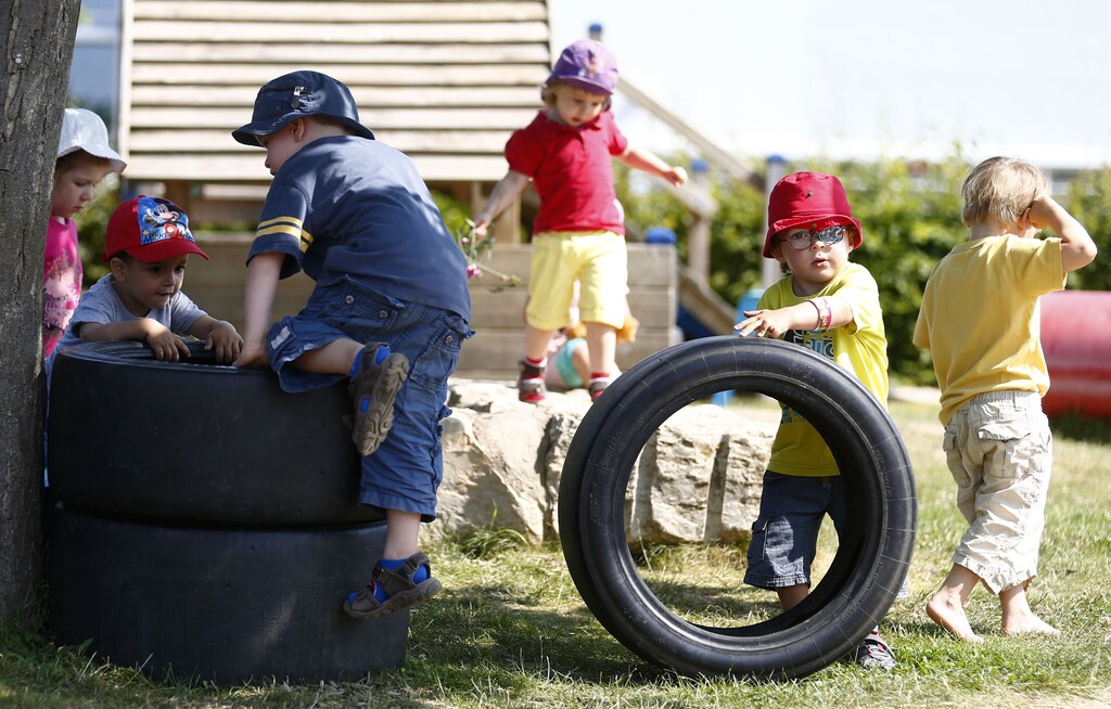 Children play in the outdoor area of the Kathinka-Platzhoff-Stiftung Kindergarten (Kathinka-Platzhoff-foundation kindergarden) in Hanau, 30km (18 miles) south of Frankfurt, July 16, 2013. From August 1, 2013, all children in Germany between the age of 1 and 3 will have a legal entitlement to a place at a kindergarten. The Kindergarten of the Kathinka-Platzhoff-Stiftung is one of few which hosts children between the age of six month and six years. Picture taken July 16. REUTERS/Kai Pfaffenbach (GERMANY - Tags: POLITICS BUSINESS EMPLOYMENT SOCIETY EDUCATION) - RTX11YEI