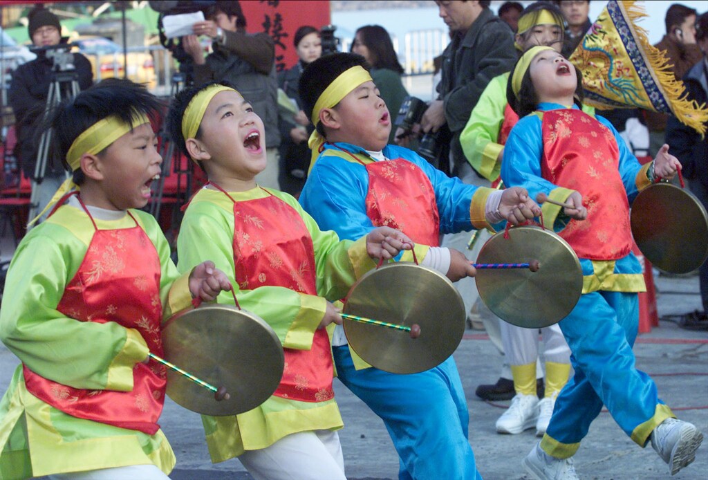 Elementary school students beat gongs January 2, 2001, to celebrate the direct sailing between Taiwan-held Quemoy island and Xiamen on China's southeast coast. Taiwan began historic direct transport links with archrival China on Tuesday as part of efforts to ease tension. - PBEAHULEWAW