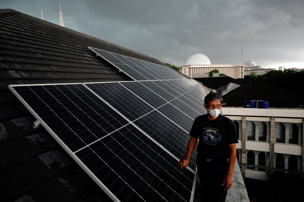 Adi Purwanto, a 56-year-old technician, walks on the roof of the Jakarta Cathedral that is installed with solar panels, in Jakarta, Indonesia, November 26, 2021. Picture taken November 26, 2021. REUTERS/Willy Kurniawan