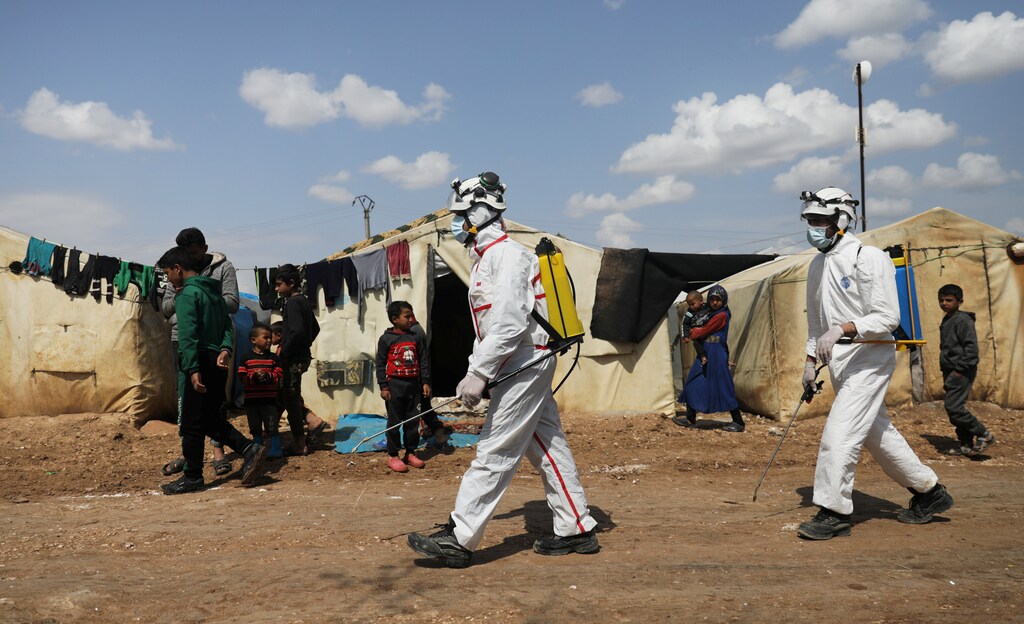 Members of the Syrian Civil defence sanitize the Bab Al-Nour internally displaced persons camp, to prevent the spread of coronavirus disease (COVID-19) in Azaz, Syria March 26, 2020. REUTERS/Khalil Ashawi - RC2TRF9PRG3F
