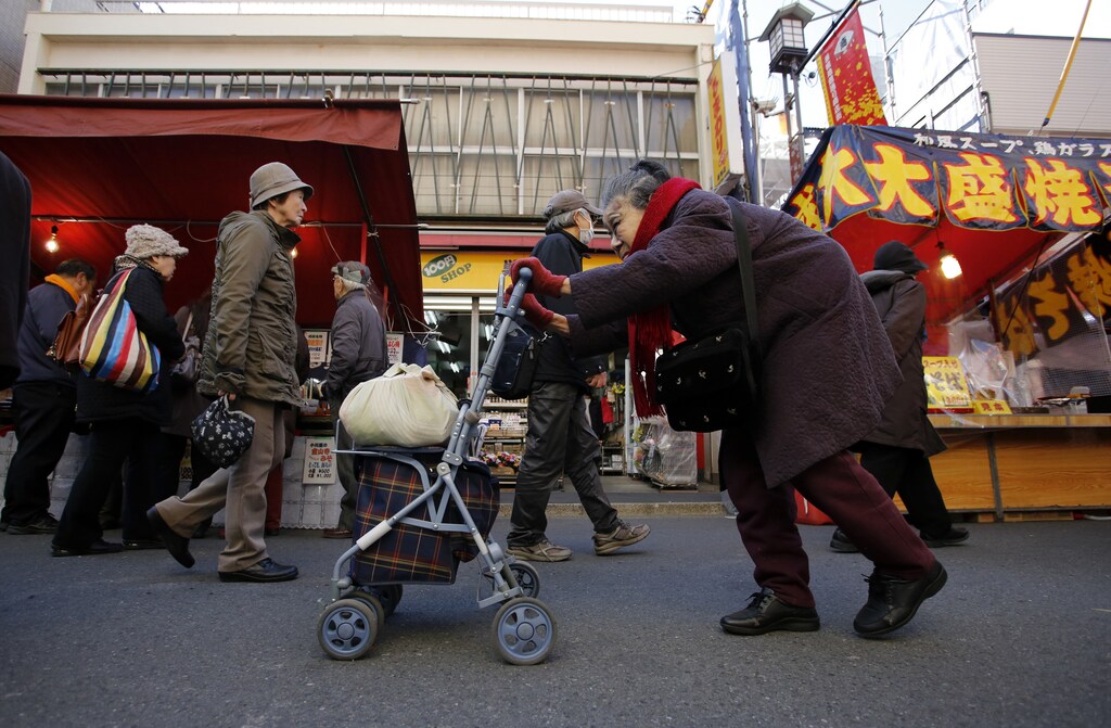 An elderly woman pushes a walking aid as she walks on a street at Tokyo's Sugamo district, an area popular among the Japanese elderly, in Tokyo January 14, 2015. Japanese Prime Minister Shinzo Abe's cabinet approved on Wednesday a record $812 billion budget for the coming fiscal year while cutting new borrowing for a third straight year in a bid to balance growth and fiscal reform. The largest budget item, social welfare spending, will rise 1 trillion yen to a record 31.53 trillion yen. REUTERS/Toru Hanai (JAPAN - Tags: SOCIETY BUSINESS POLITICS TPX IMAGES OF THE DAY) - GM1EB1E15IG01