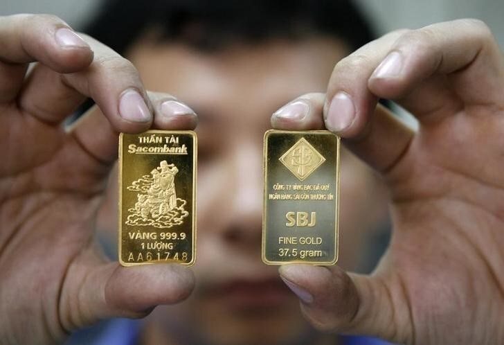 A man displays gold bars at the Sacombank gold bar factory in Vietnam's southern Ho Chi Minh city January 22, 2010. REUTERS/Kham (VIETNAM - Tags: BUSINESS)