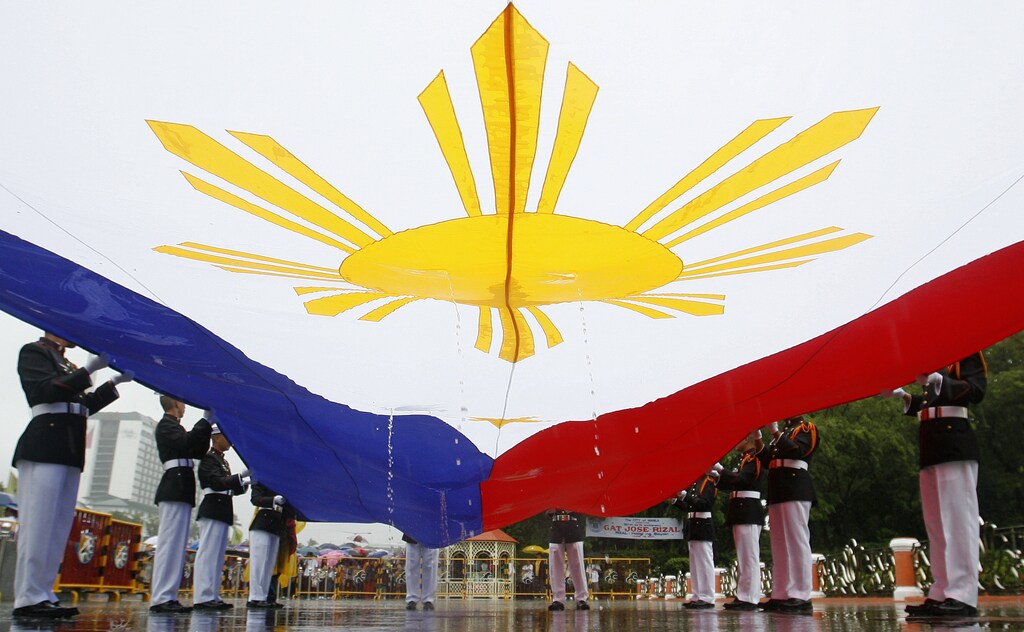 The Philippine national flag is drenched in rainwater before it is raised during celebrations for the 150th birth anniversary of Philippine national hero Jose Rizal at the Rizal Park in Manila June 19, 2011. REUTERS/Cheryl Ravelo (PHILIPPINES - Tags: ANNIVERSARY SOCIETY) - GM1E76J0VRO01