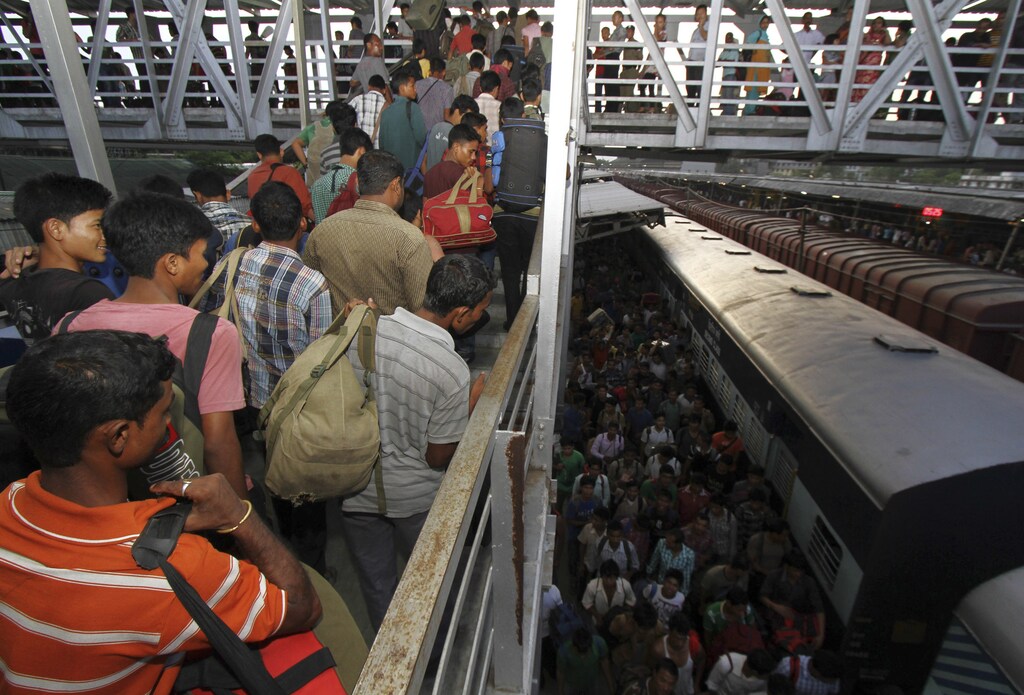 People from India's northeastern states, walk at the platform upon their return from southern Indian states, at the railway station in Guwahati in the northeastern Indian state of Assam August 18, 2012. Indian Prime Minister Manmohan Singh assured migrants from the northeast that they were safe as thousands fled Mumbai, Bangalore and other cities on Friday, fearing a backlash from violence against Muslims in Assam. REUTERS/Utpal Baruah (INDIA - Tags: TRANSPORT CIVIL UNREST RELIGION POLITICS) - GM1E88I150301