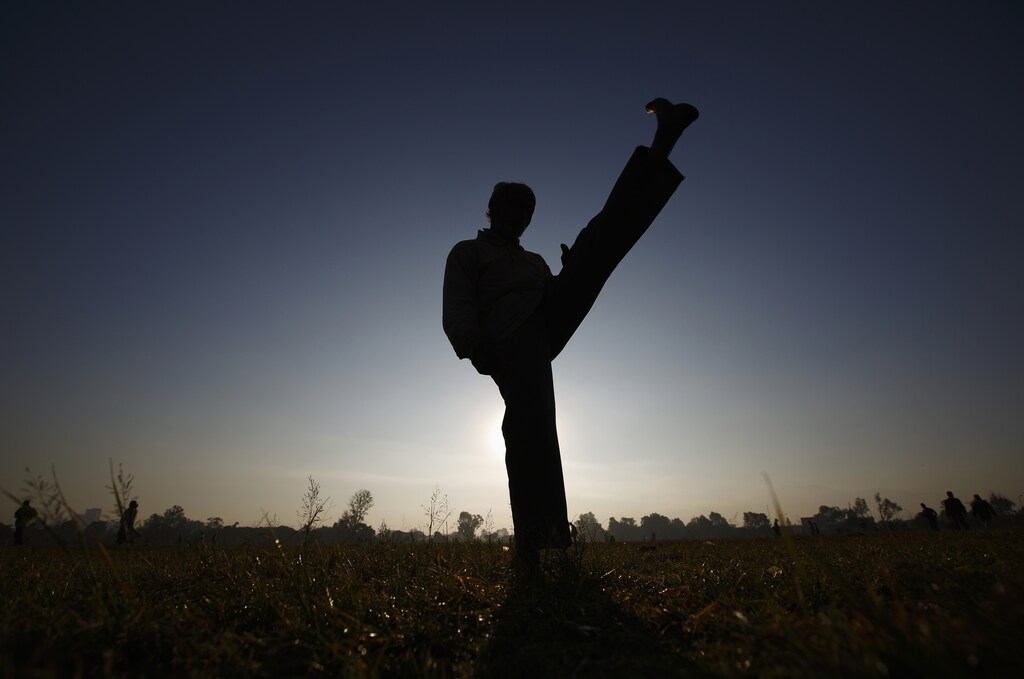 A Nepalese man kicks as he exercises in the early morning a day after the Constituent Assembly election in Kathmandu November 20, 2013. Millions of Nepalis voted on Tuesday for an assembly that will draft a constitution aimed at ending years of instability but their ballots may not produce a conclusive result and could leave the country facing more turmoil. REUTERS/Navesh Chitrakar (NEPAL - Tags: ELECTIONS POLITICS SOCIETY) - GM1E9BK14UC01