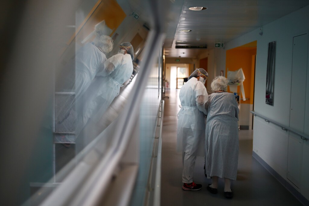 A physiotherapist, wearing a protective mask and a protective suit, works in a pulmonology unit at the hospital in Vannes where patients suffering from the coronavirus disease (COVID-19) are treated, France, October 12, 2020. REUTERS/Stephane Mahe