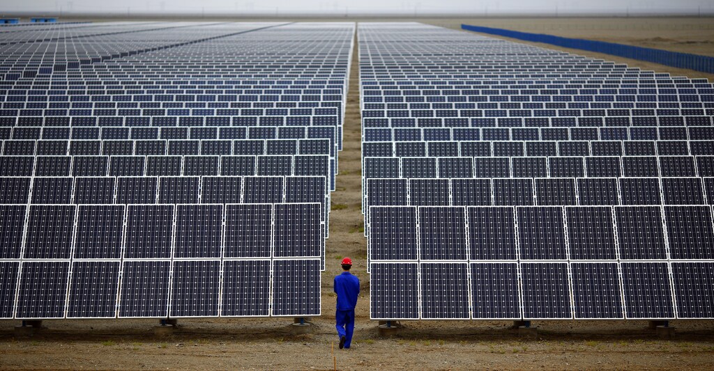 A worker inspects solar panels at a solar Dunhuang, 950km (590 miles) northwest of Lanzhou, Gansu Province September 16, 2013.