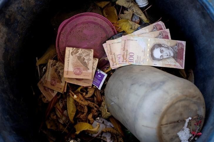 Venezuelan 100 bolivar notes thrown by people in a trash bin are seen at a gas station of the Venezuelan state-owned oil company PDVSA in Caracas, Venezuela August 20, 2018. REUTERS/Marco Bello TPX IMAGES OF THE DAY