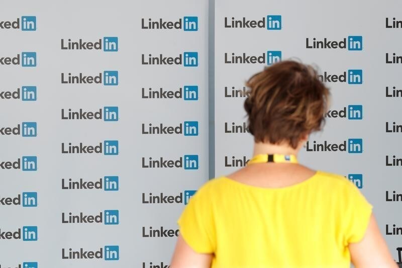 A visitor looks at logos of LinkedIn Corporation at the MEDEF union summer forum on the campus of the HEC School of Management in Jouy-en-Josas, near Paris, France, August 29, 2017. REUTERS/Charles Platiau - RC128637DD30