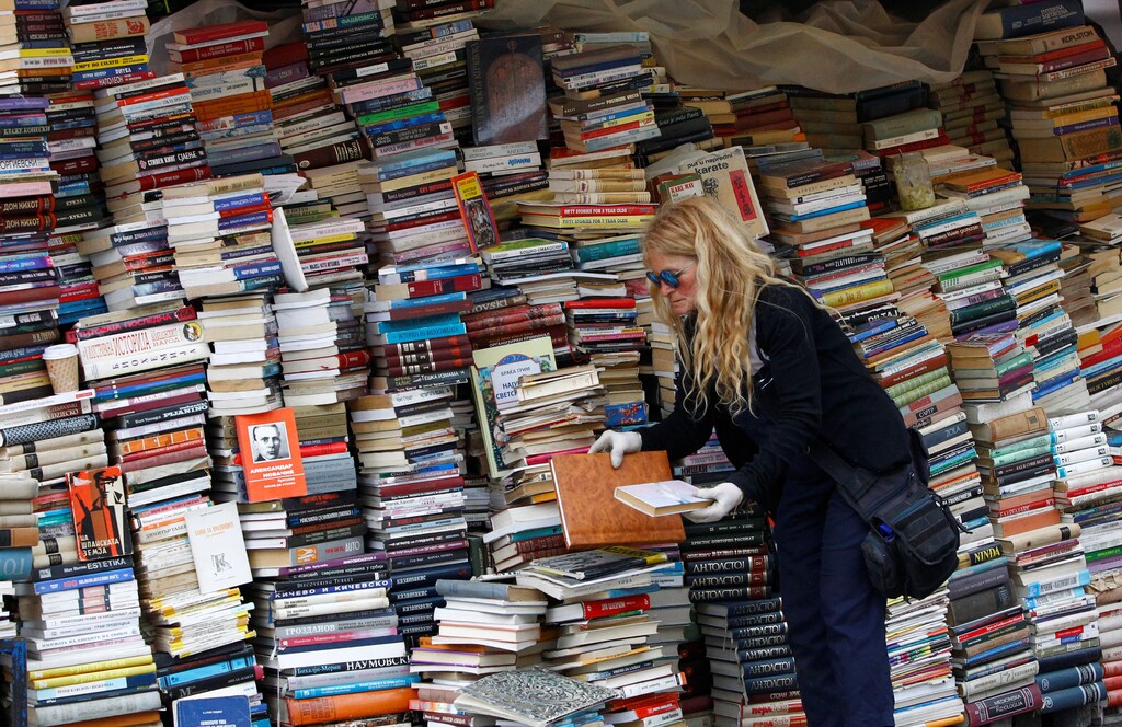 A woman arrange books at her open air book store in Skopje, Macedonia May 9, 2017. REUTERS/Ognen Teofilovski - RTS15WVK