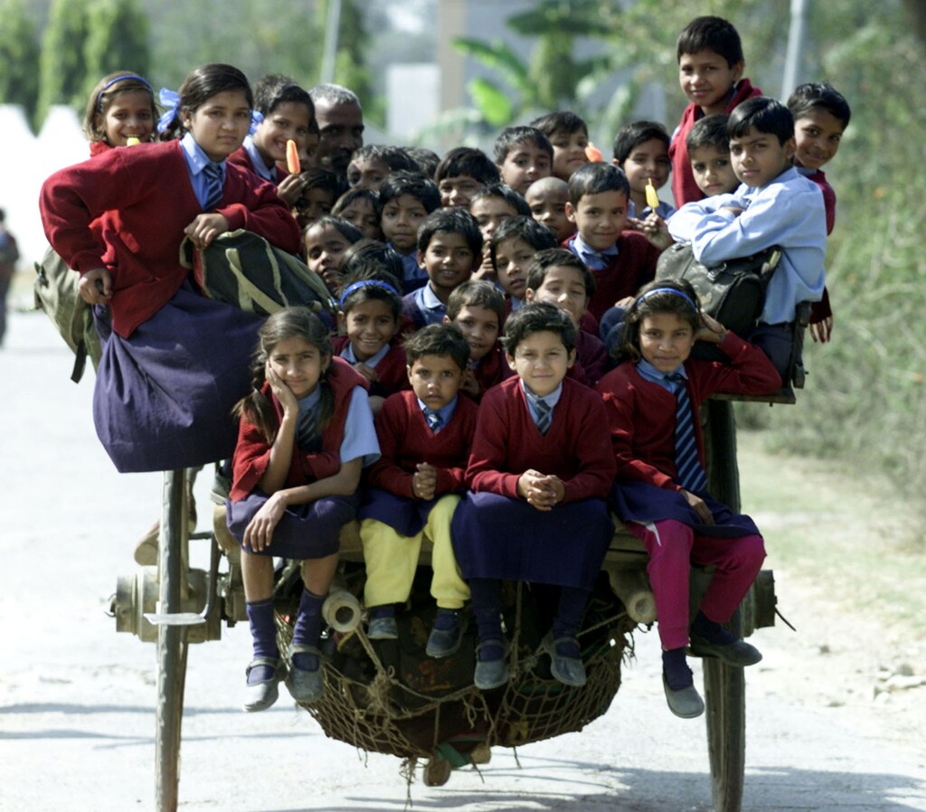 Indian children ride in a cart on the way home from school in the outskirts of New Delhi