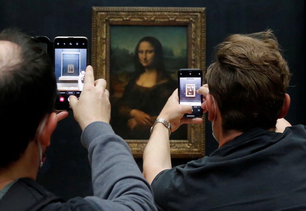 Visitors take pictures of the painting "Mona Lisa" (La Joconde) by Leonardo da Vinci at the Louvre museum in Paris as the museum reopens its doors to the public after an almost four-month closure due to the coronavirus disease (COVID-19) outbreak in France, July 6, 2020. REUTERS/Charles Platiau TPX IMAGES OF THE DAY - RC2MNH9MZ98D