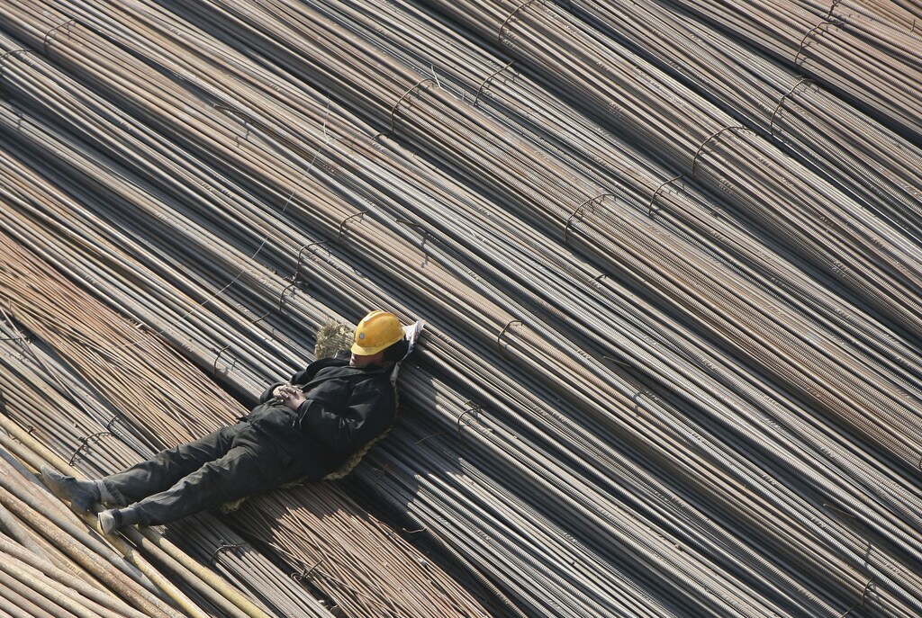 A labourer takes a nap on reinforcement bars at a construction site in Qingdao, Shandong province March 5, 2008. Chinese Premier Wen Jiabao warned on Wednesday that overheating remains his nation's top economic foe even as global growth softens, vowing a tough fight against price rises and feverish investment. Picture taken March 5, 2008. REUTERS/Stringer(CHINA) CHINA OUT - GM1E4360VUG01