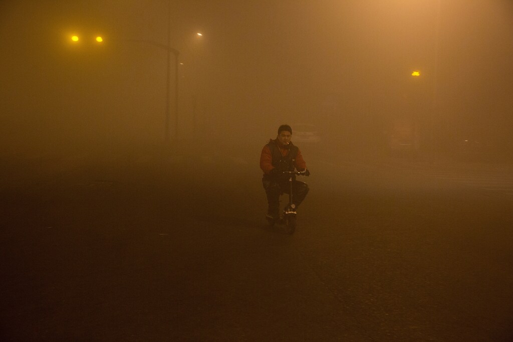 A man smokes as he rides in smog during polluted day in Beijing, China, December 20, 2016. REUTERS/Stringer ATTENTION EDITORS - THIS IMAGE WAS PROVIDED BY A THIRD PARTY. EDITORIAL USE ONLY. CHINA OUT. NO COMMERCIAL OR EDITORIAL SALES IN CHINA. - RC1A854E6120