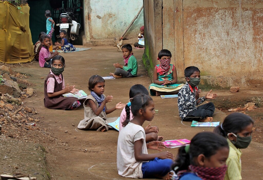 Children, who have missed their online classes due to a lack of internet facilities, sit on the ground in circles drawn with chalk to maintain a safe distance, as they listen to pre-recorded lessons over loudspeakers, after schools were closed following the coronavirus disease (COVID-19) outbreak, in Dandwal village in the western state of Maharashtra, India, July 23, 2020. Picture taken July 23, 2020. REUTERS/Prashant Waydande - RC2P6I92PEZD
