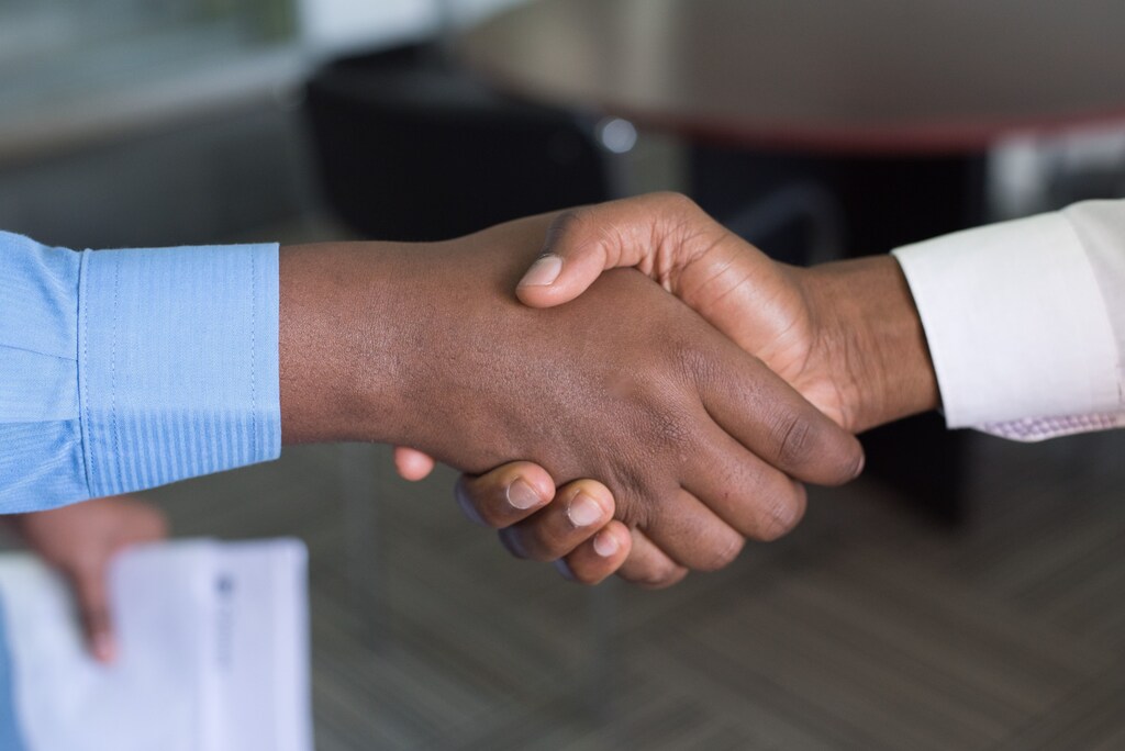Two men shake hands.