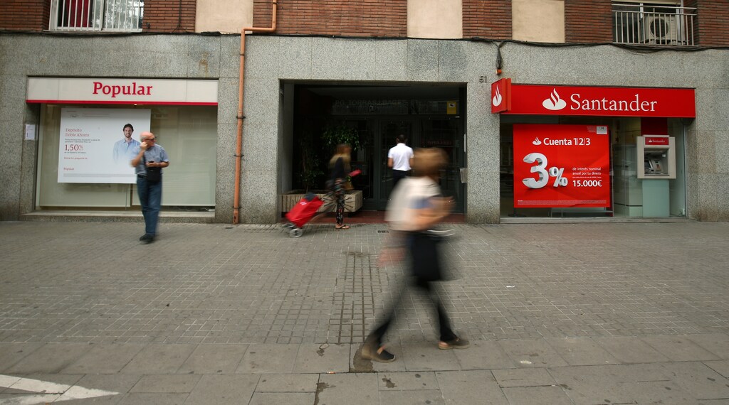 People walk past a Banco Popular and Santander bank offices in Barcelona, Spain June 7, 2017. REUTERS/Albert Gea - RC170C980A10