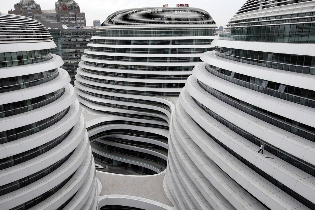 A worker cleans an exterior of a newly built urban complex building accommodating offices and retail shops in Beijing October 14, 2013. REUTERS/Kim Kyung-Hoon (CHINA - Tags: BUSINESS CONSTRUCTION TPX IMAGES OF THE DAY) - GM1E9AE1BGU01