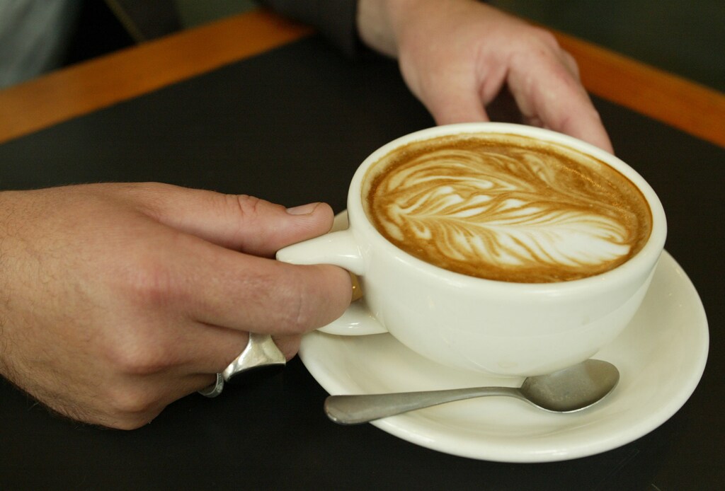 Bryan Yeck, owner of Zeitgeist Kunst and Kafee in downtown Seattle, holds a latte at his cafe in downtown Seattle on September 11, 2003. Seattle voters go to the polls for a special election on September 16 to vote on Initiative 77 which calls for a 10-cent tax on every cup of espresso or espresso-based coffee drink to fund better child care for low-income families. Seattle is the hometown and headquarters of Starbucks. Both small cafes like Zeitgeist and big coffee companies like Starbucks are opposed to the tax. CPROD REUTERS/Anthony P. Bolante APB - RP4DRIFRHGAA