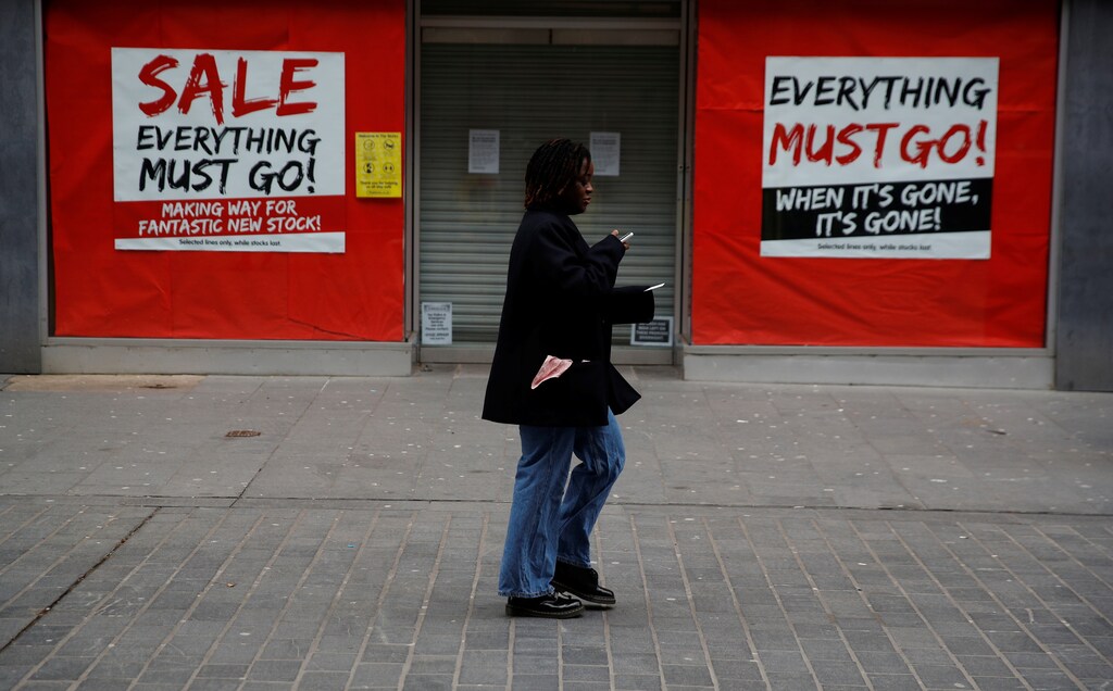 A woman walks past a closed shop advertising a sale amid the outbreak of the coronavirus disease (COVID-19) in Liverpool, Britain, February 23, 2021.