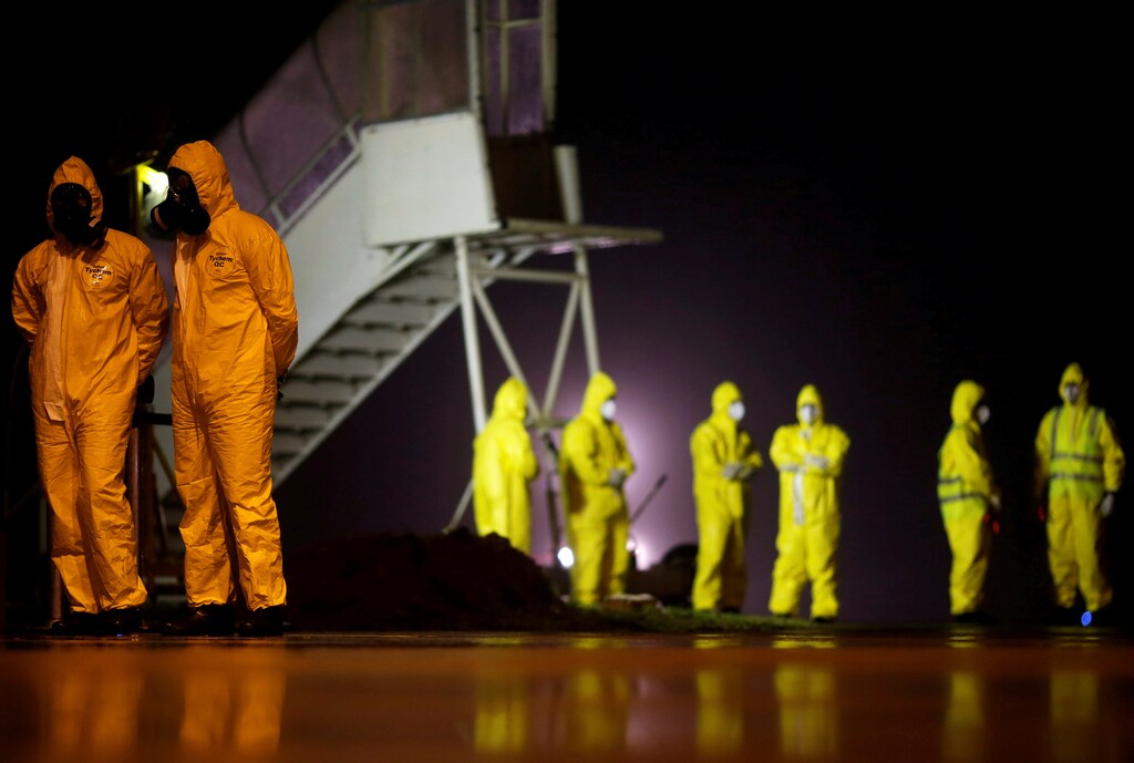 Los soldados visten trajes protectores antes de que los ciudadanos brasileños del Wuhan golpeado por el coronavirus de China lleguen a la base de la Fuerza Aérea de Anapolis, Estado de Goias, Brasil, el 9 de febrero de 2020.
