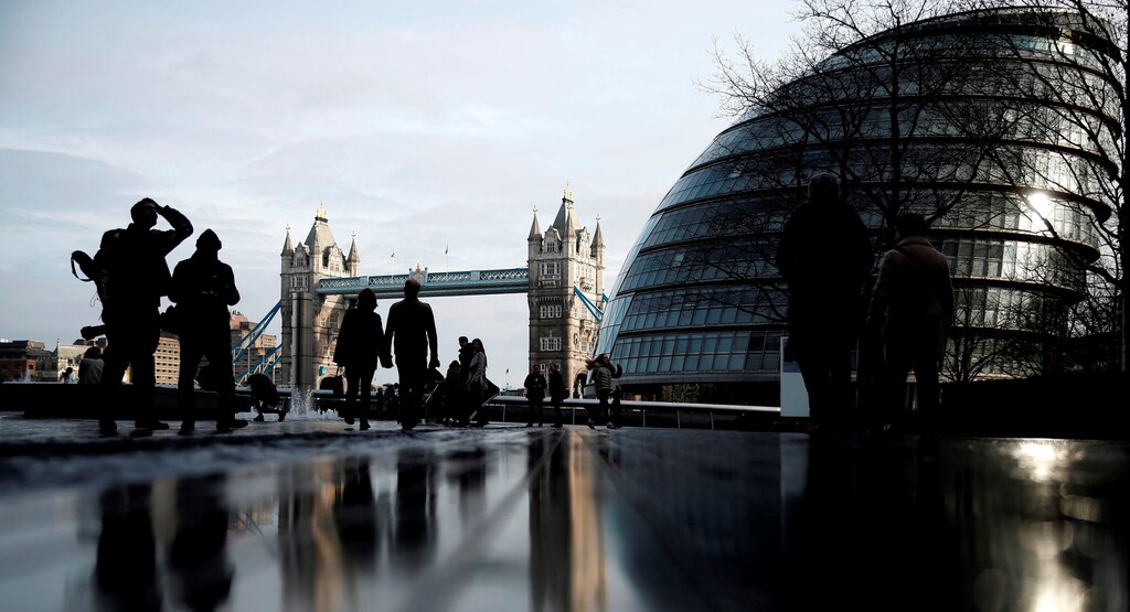 Pedestrians walk near City Hall and Tower Bridge in London, Britain January 24, 2016.