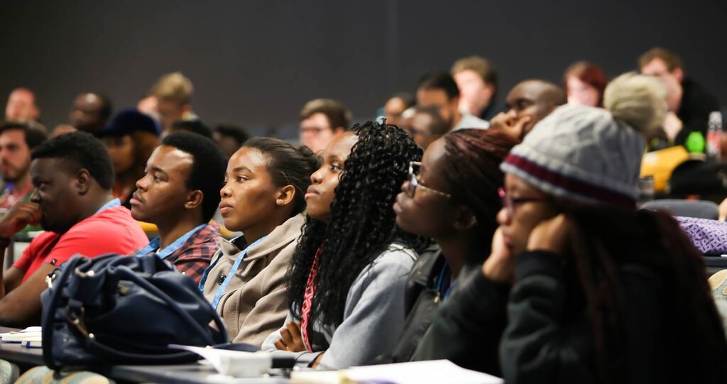 Attendees of the Deep Learning Indaba listen to a speaker in a lecture hall at Stellenbosch University, South Afric