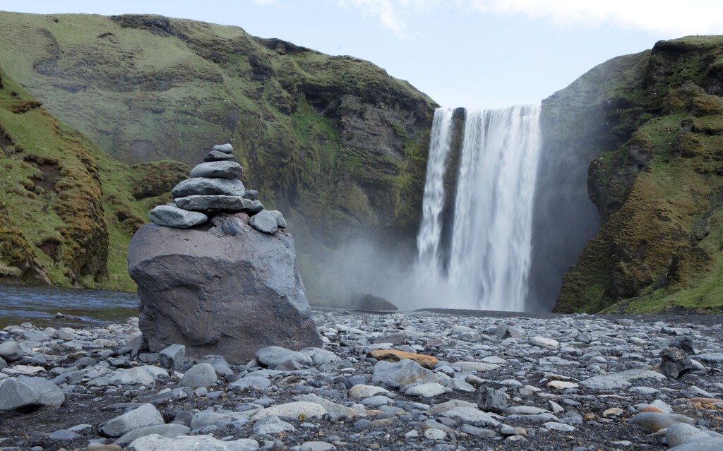 A pile of rocks stand in front of a waterfall in Skogarfoss, Iceland May 28, 2011. REUTERS/Lucas Jackson (ICELAND - Tags: ENVIRONMENT TRAVEL) - GM1E75T04MM01